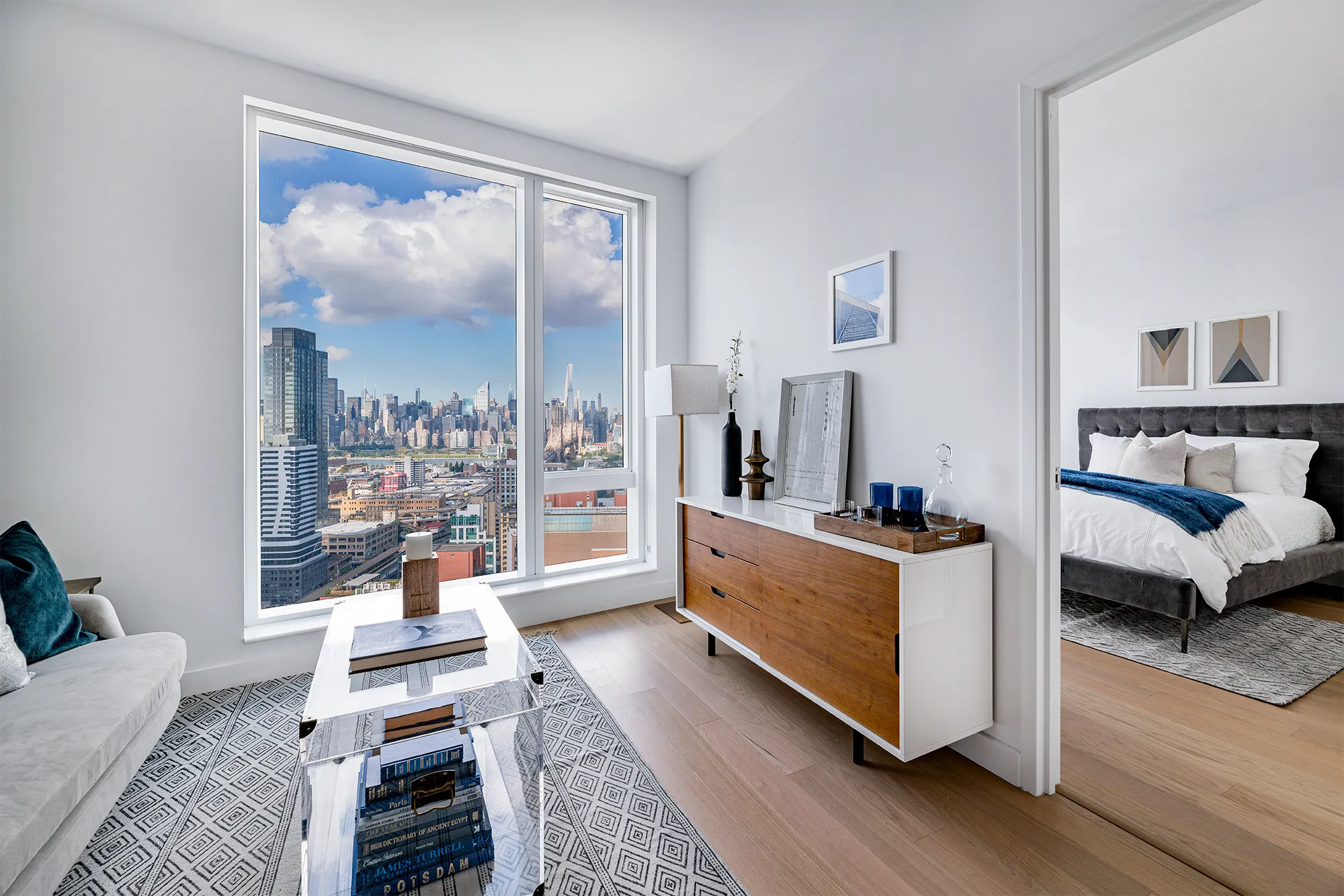Modern entertainment/living room space with hardwood floors and floor-to-ceiling windows