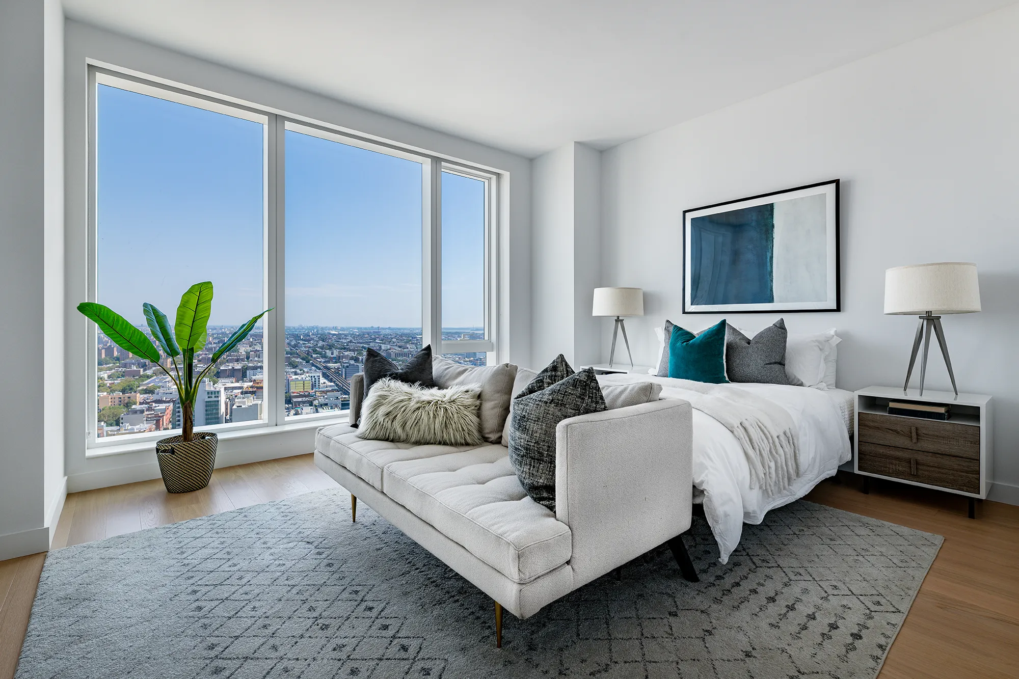 Modern high-rise bedroom with wood floors and expansive view of Queens New York