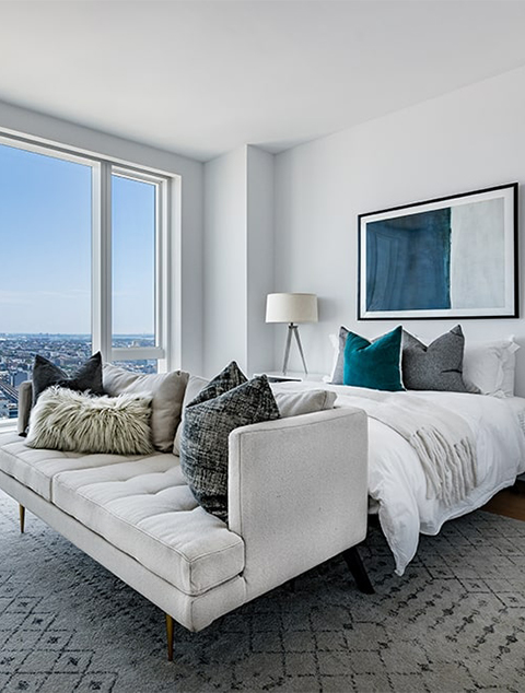Modern high-rise bedroom with wood floors and expansive view of Queens New York
